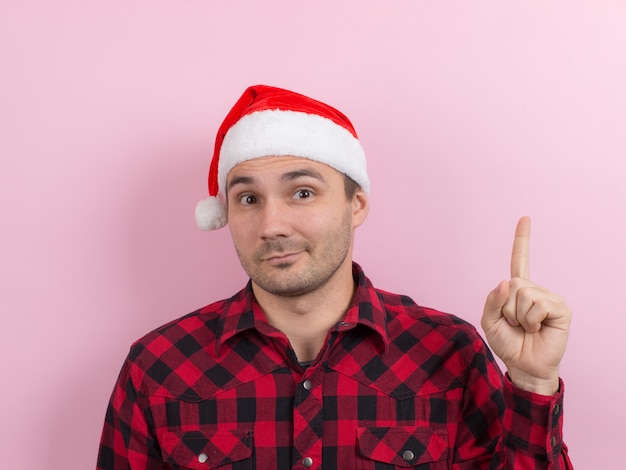 Emotions on the face, pensive, reflection, plan, idea. A man in a plaid rabbit and a Christmas red hat