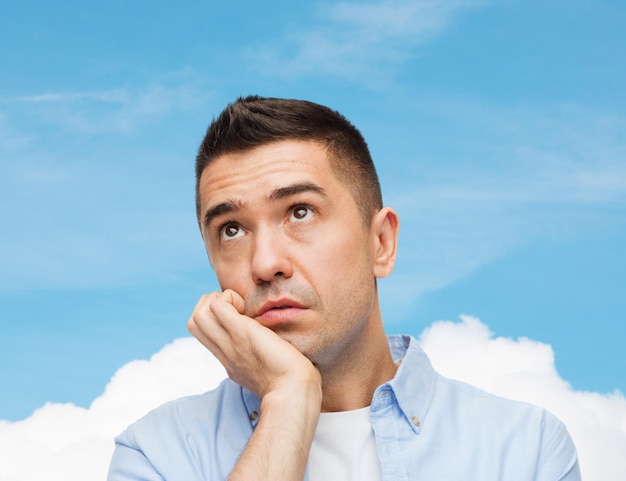 emotions and people concept - sad middle aged man over blue sky and cloud background