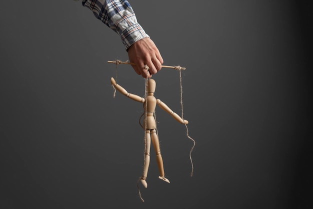 The emploee holding a marionette wooden doll manipulation concept