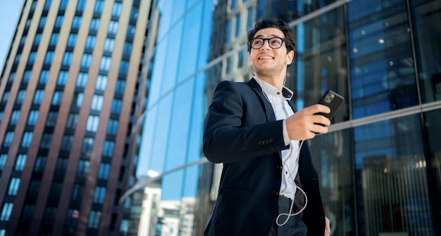 An employee of the company goes to work holds a phone in his hands talks through headphones