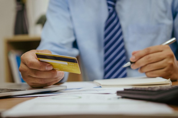 Employee of a company paying a charge with a credit card while conducting internet shopping Concept of tax and accounting in business