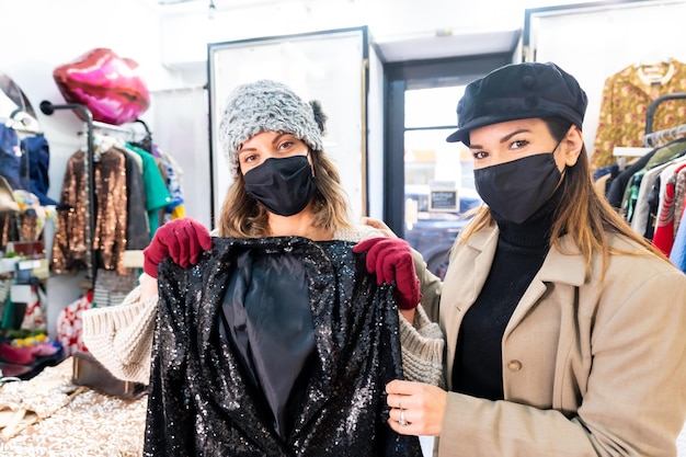 Employee of a luxury clothing store showing a sequin dress, security measures in the coronavirus pandemic, covid-19