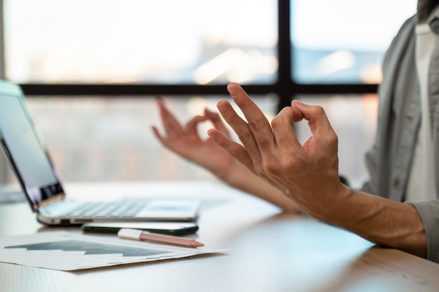 Employee meditates breathing deeply at workplace in office