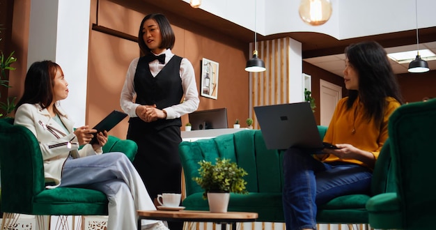 Employee offering information to asian tourists in lobby