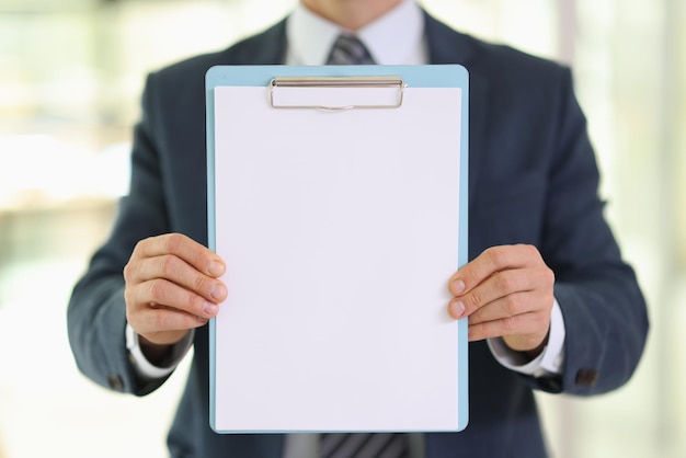 Employee shows blank paper sheet on clipboard in company office manager holds empty document