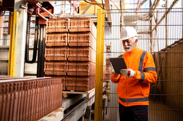 Employee standing by packaging machine and controlling the process