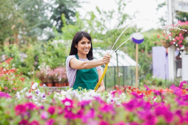 Employee watering plants with hose