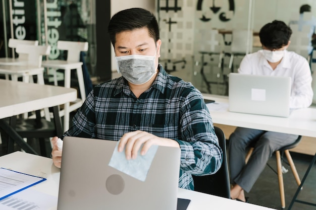 Employees are spraying with alcohol to wipe clean office equipment