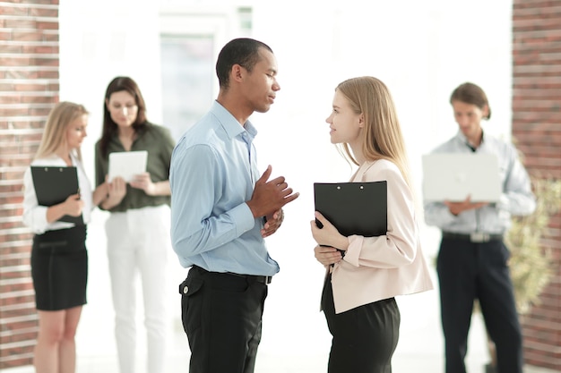 Employees discussing business document standing in the office