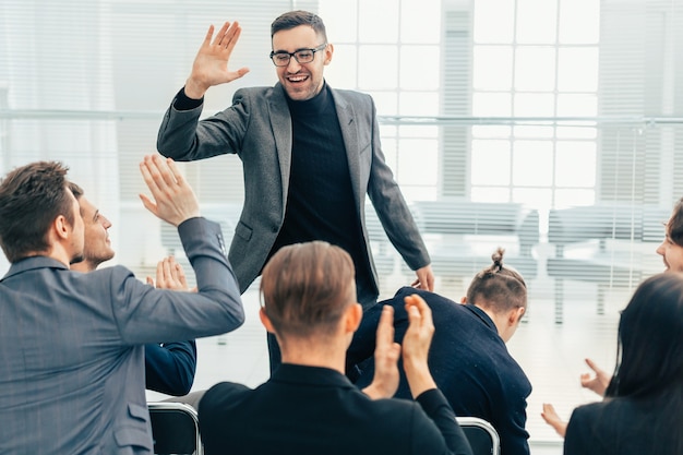 Employees giving each other a high five during a work meeting . concept of success