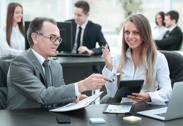 Employees using digital tablet to work with financial data