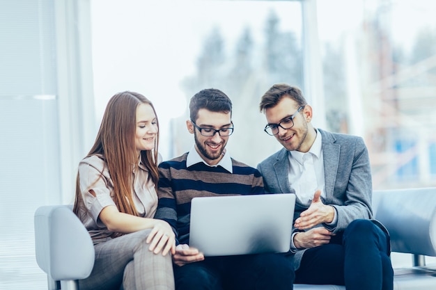 Employees with a laptop sitting in the lobby of the office