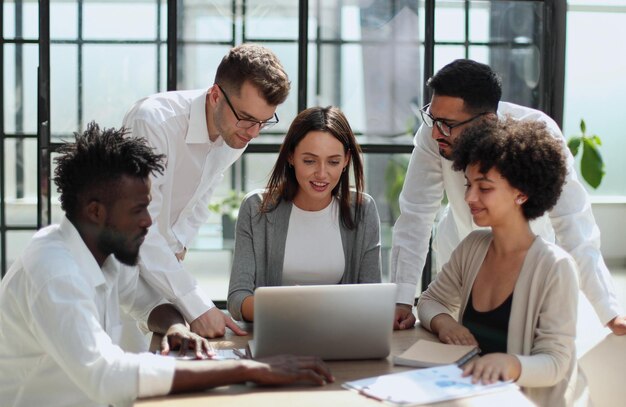 Employees working at computer together discussing content