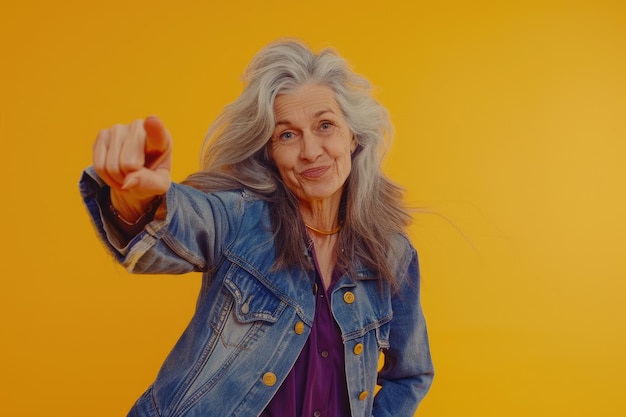 Empowered senior woman in stylish outfit points at camera