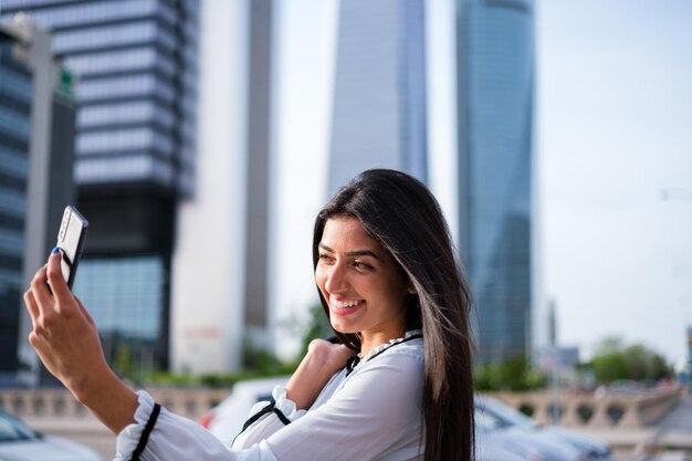 Empowered young woman taking a selfie in financial district