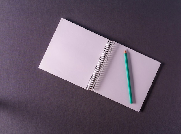 An empty A4 notebook in expanded form on a gray textured background top viewmockup