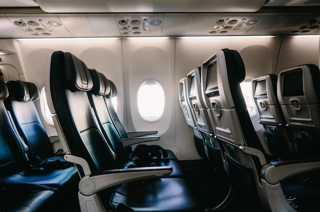 Empty airplane seats seen from inside with window and copyspace