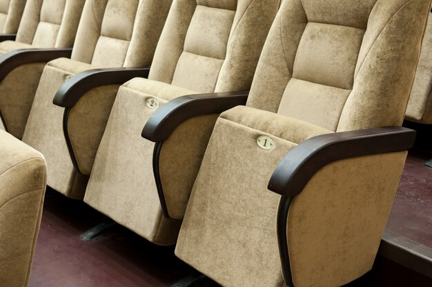 Empty auditorium with beige chairs, theatre or conference hall.