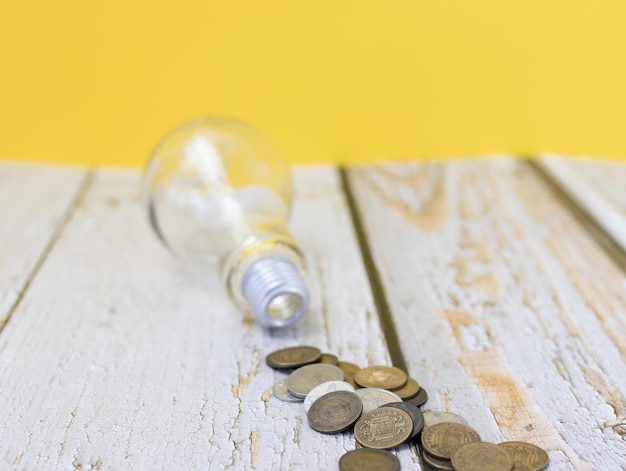 Empty background light bulb and coins on the table