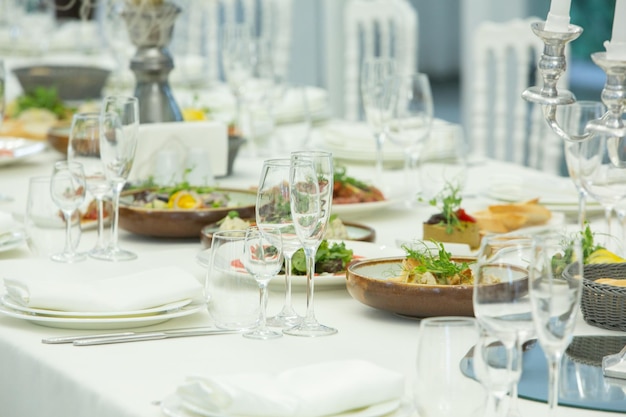 Empty banquet hall ready to receive guests on the summer terrace. white festive table