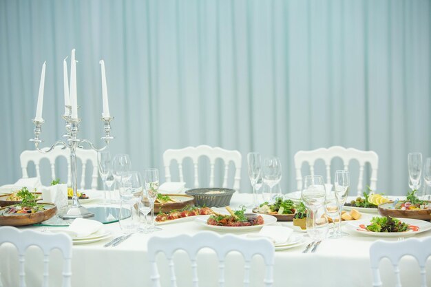 Empty banquet hall ready to receive guests on the summer terrace. white festive table