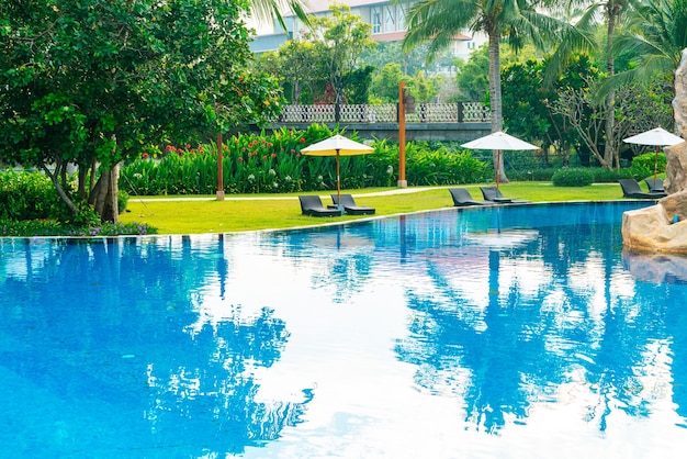 empty beach chair with umbrella around swimming pool