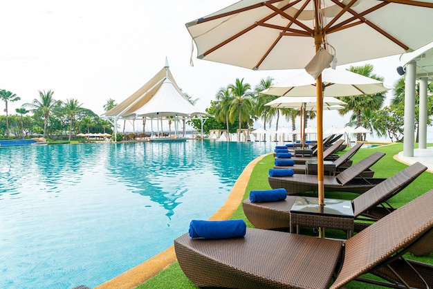 empty beach chair with umbrella around swimming pool