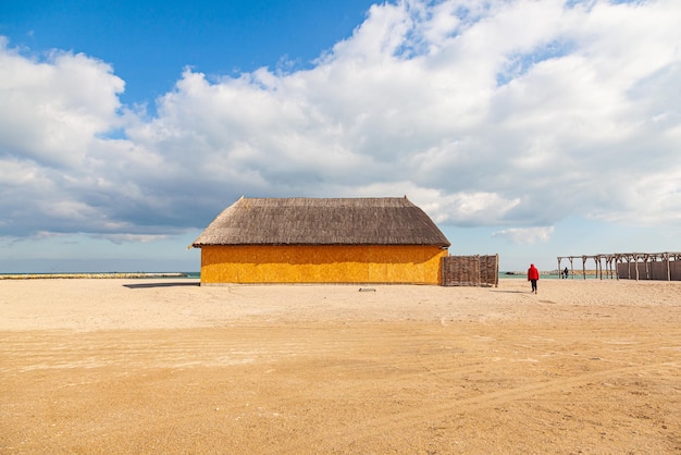 Empty beach with a thatched roof hut and the sea in early spring on a sunny day