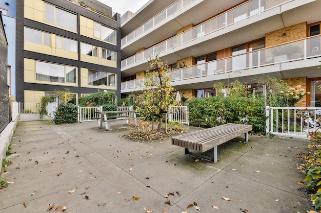 An empty bench in front of an apartment building