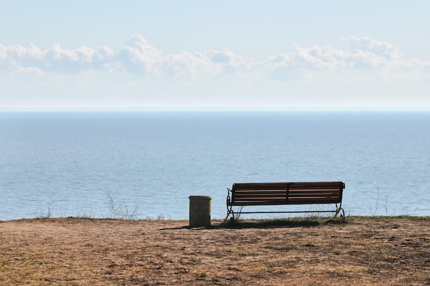 Empty bench with trashcan on cliff before sea background peaceful quiet place for thinking alone