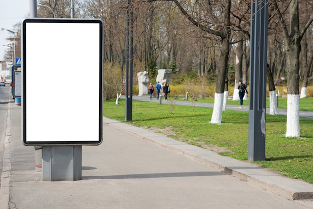 Empty billboard or lightbox on green city street with white isolated background