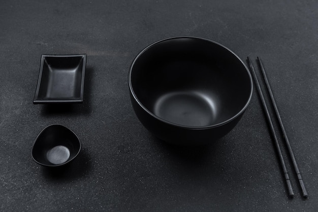 Empty black ceramic plate on a background of black stone top view flat plan