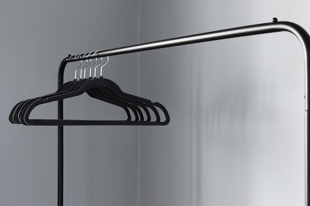 Empty black clothes hanger on gray wall background