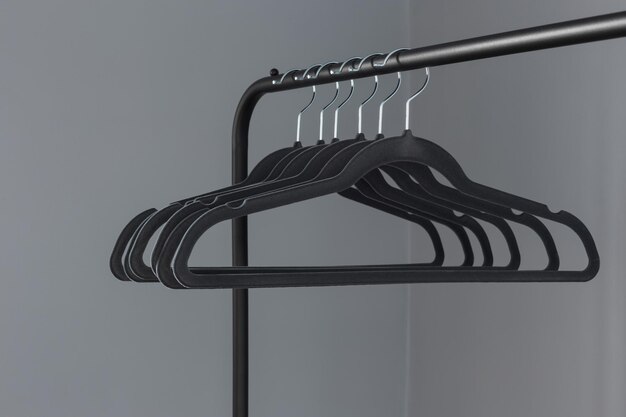 empty black clothes hanger on gray wall background