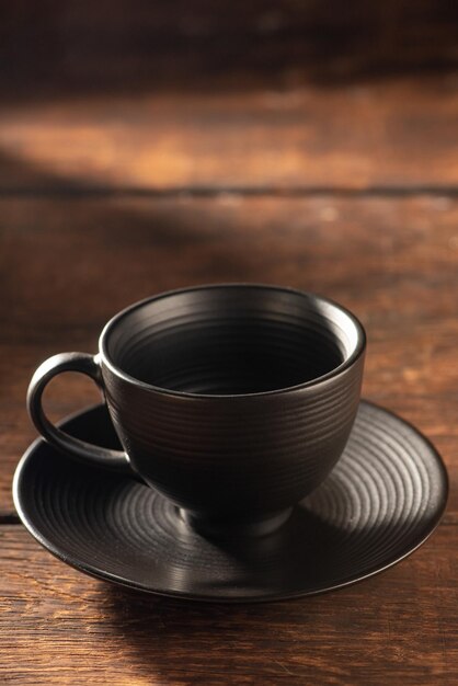 Empty black coffee cup on rustic wood dark food style photo selective focus