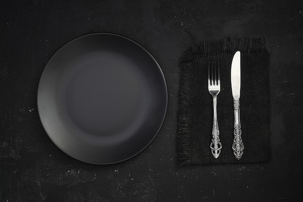 Empty black slate plate on stone table Flatlay top view Mockup for restaurant dish