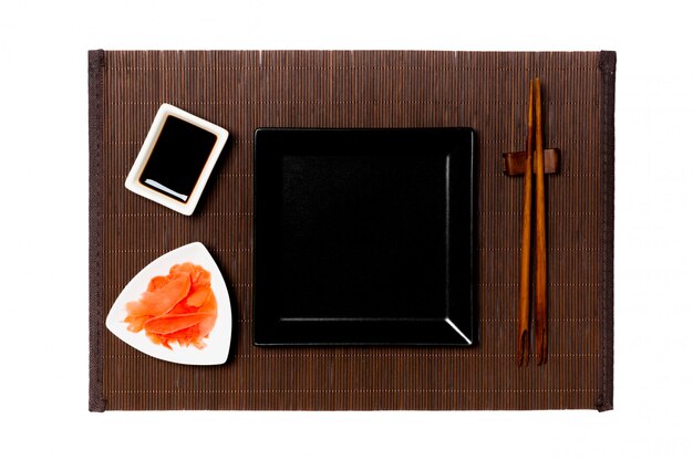 Photo empty black square plate with chopsticks for sushi