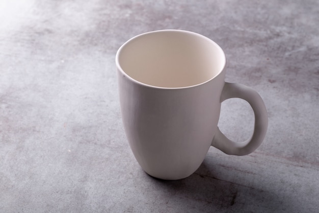 Empty blank white ceramic cup on Cement Board