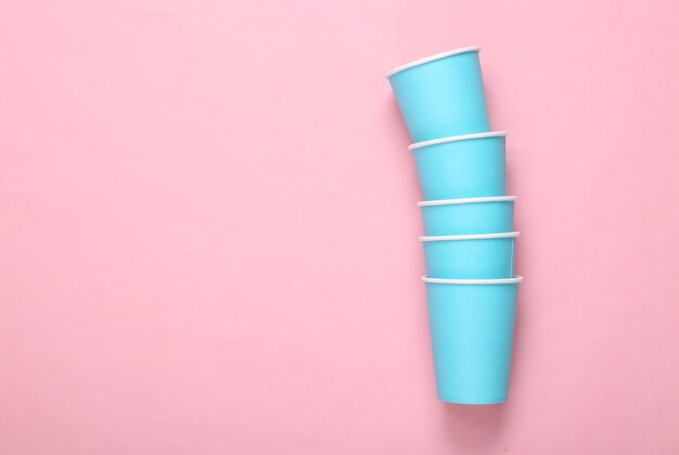 Empty blue cardboard cups on a pink background