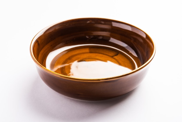 Empty brown ceramic serving bowl, isolated over white or gray surface