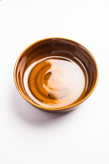 Empty brown ceramic serving bowl, isolated over white or gray surface