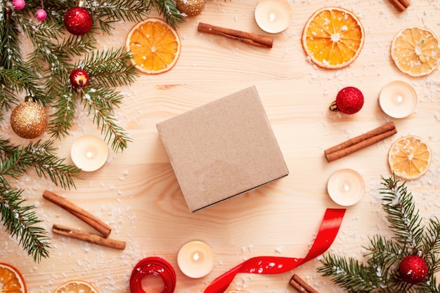 Empty brown paper box with christmas decoration around on wooden table