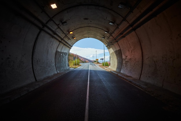 Empty car road in illuminated tunnel