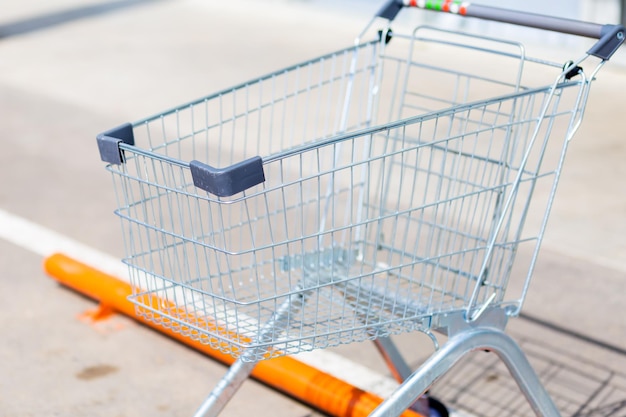 Empty cart on wheels for groceries in a hypermarket on a blurred background