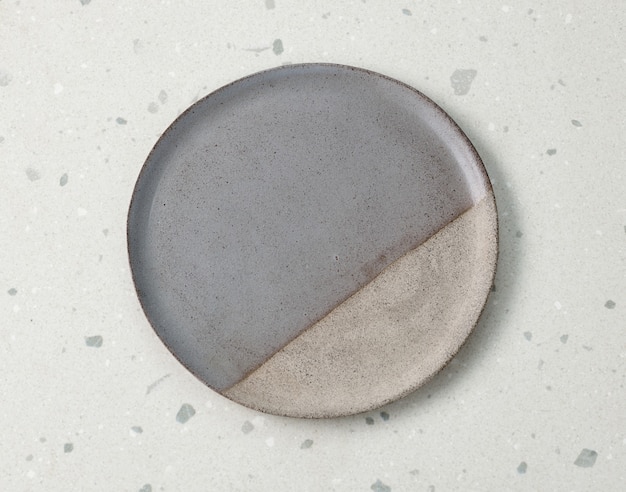 Photo empty ceramic plate on grey kitchen table, top view