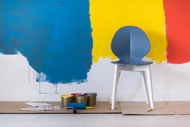 empty chair and equipment for painting in front of colorful wall in the background