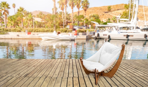 Empty chair on wooden platform by marina