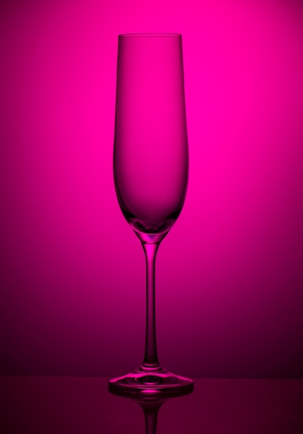 Empty champagne glass on a pink background