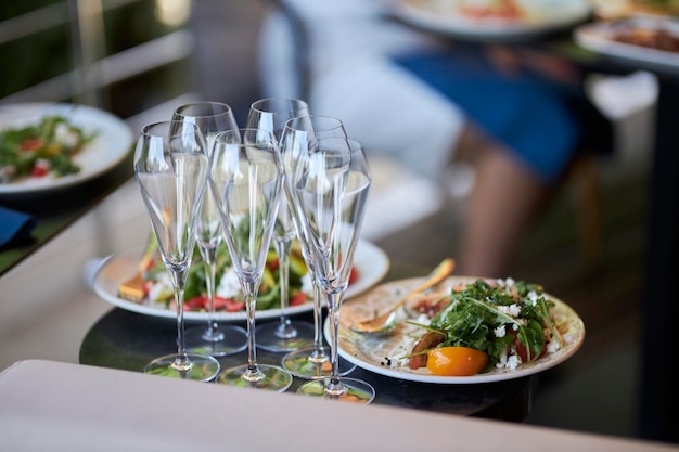 empty champagne glasses and plates with food on the table closeup