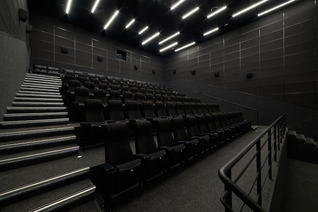 Empty cinema hall with black seats Movie theatre nobody